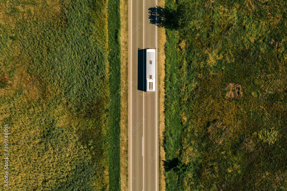 Aerial view of passenger bus on road through countryside Aerial view of passenger bus on road through countryside