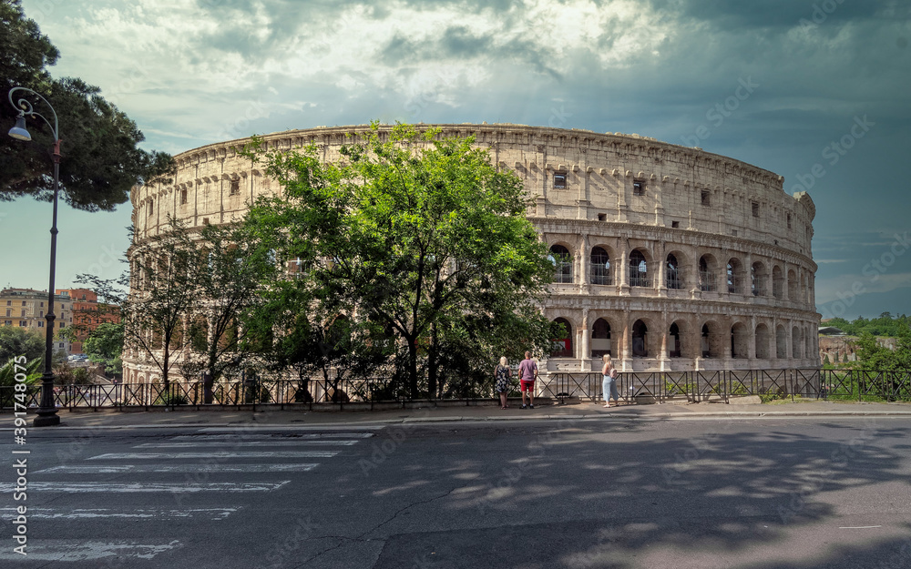 road to Colosseum ancient arena under dramatic sky, Rome Italy