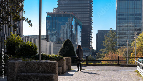 working woman in a recreation area at the entrances to a skyscraper of AZCA business and financial district in Madrid, Spain.