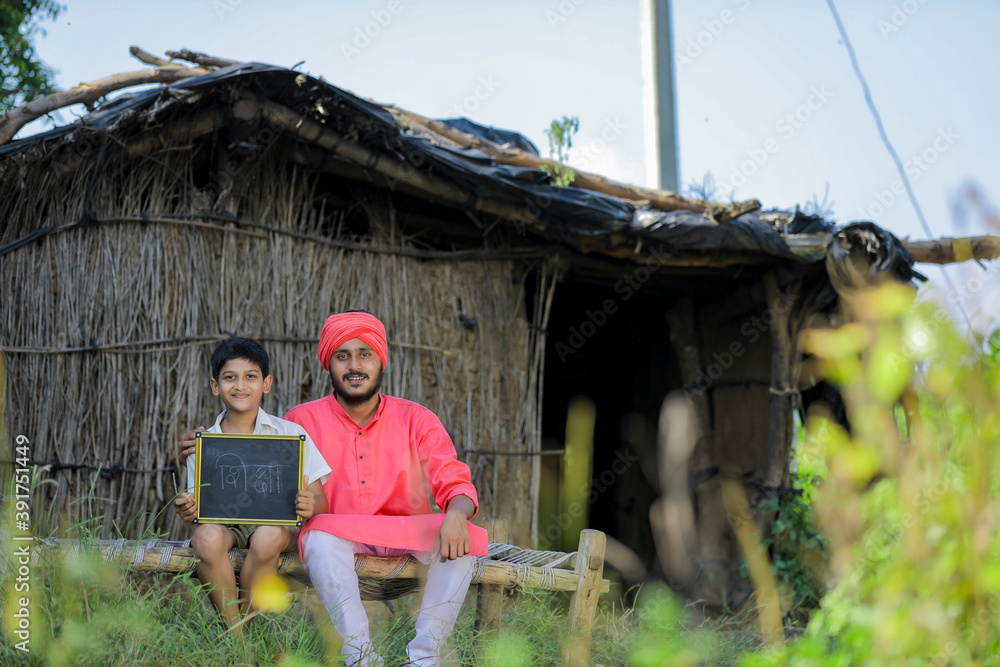 Cute indian farmer child studying with his father at home Cute indian farmer child studying with his father at home