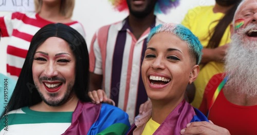 Happy gay people laughing in front of camera at lgbt pride party