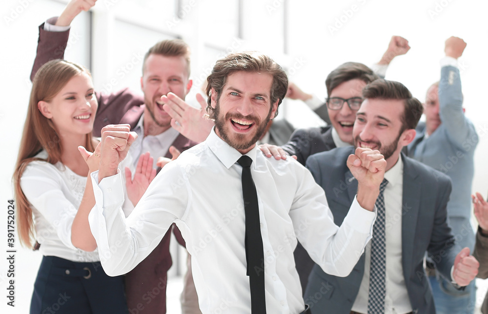 happy young businessman standing in front of his business team