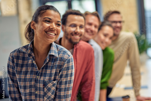 Successful startup team. Group of young happy multiethnic colleagues smiling while posing in the modern office, business people working together