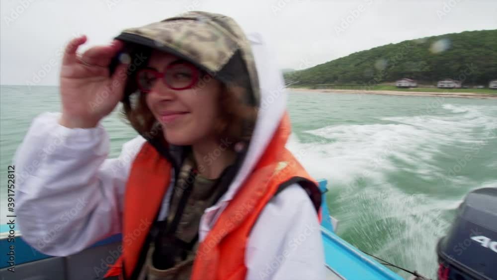 Motor of the motor boat sailing in the sea, foamy trace and portrait of smiling young woman enjoying adventure Motor of the motor boat sailing in the sea, foamy trace and portrait of smiling young woman enjoying adventure