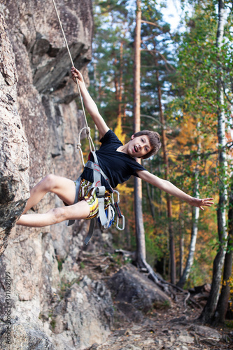 cute teen kid climbing on rock with insurance, lifestyle sport people concept