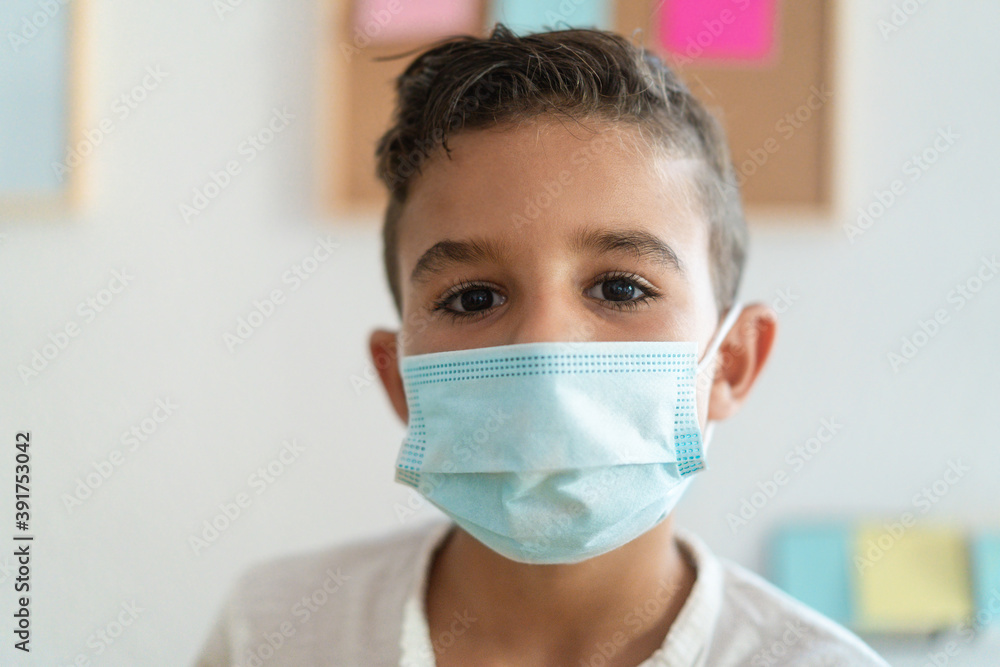 Boy at school wearing protective face mask - Social distance during coronavirus outbreak concept - Focus on face Boy at school wearing protective face mask - Social distance during coronavirus outbreak concept - Focus on face