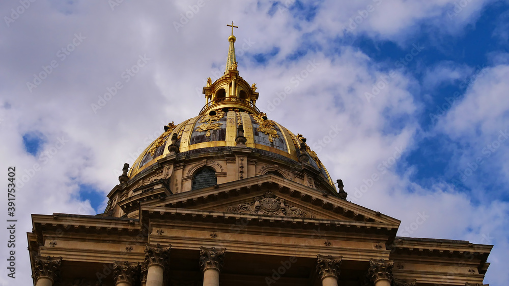 Closeup view of the golden colored majestic dome of historic Les Invalides cathedral in the center of Paris, France, grave of Napoleon Bonaparte on sunny day with blue sky and partly clouds. Closeup view of the golden colored majestic dome of historic Les Invalides cathedral in the center of Paris, France, grave of Napoleon Bonaparte on sunny day with blue sky and partly clouds.
