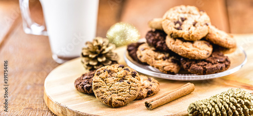 American Christmas tradition, cookie for Santa Claus on a plate, with glass of defocused milk in the background. Christmas tradition in the United States of America