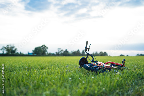 A Bike On The Ground In A Field of Grass In the Summer