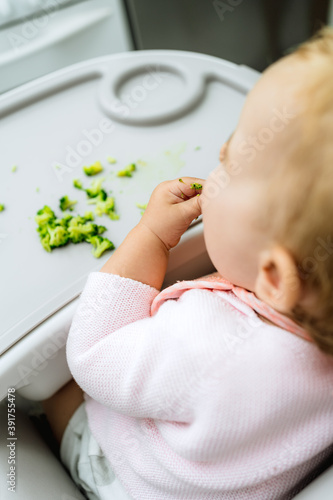 baby eating broccoli with hands, stages of baby-led weaning