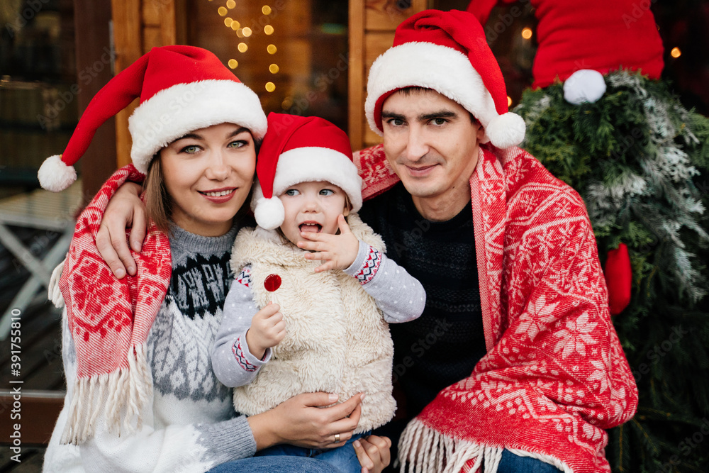 A family in Christmas hats on the doorstep. A family in Christmas hats on the doorstep.