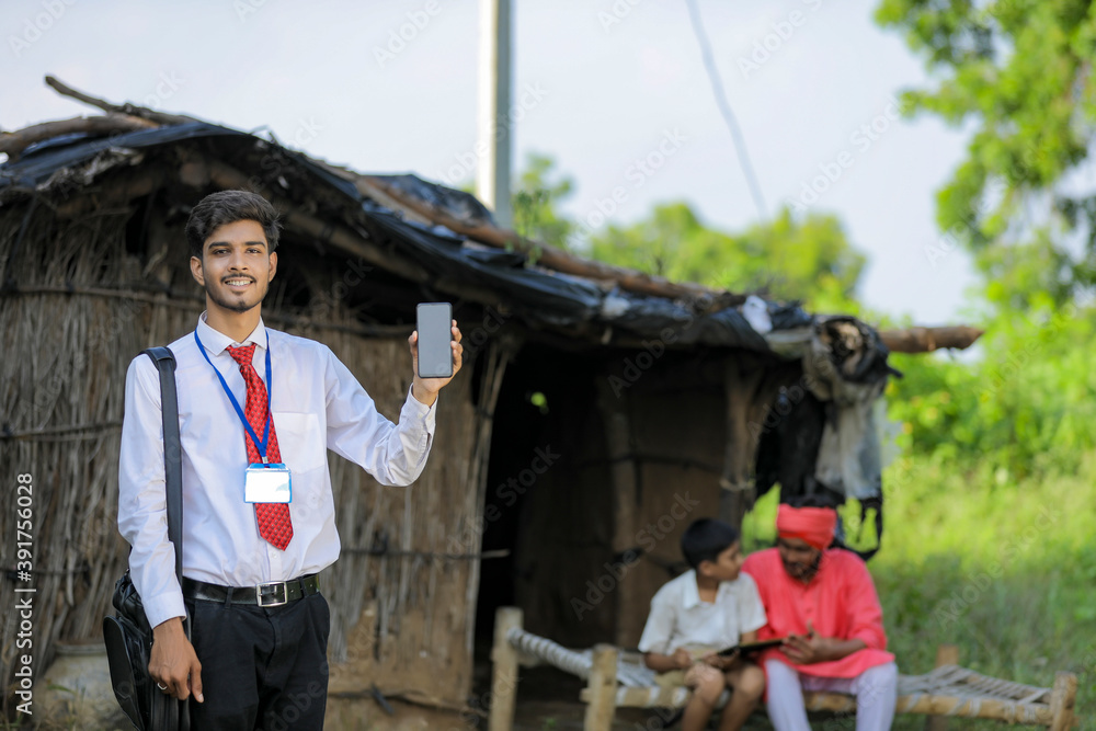 Young indian bank officer showing mobile screen with farmer Young indian bank officer showing mobile screen with farmer