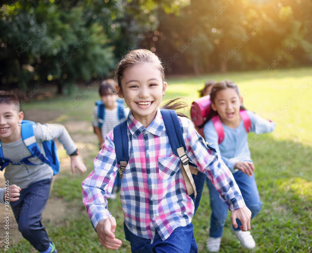 Group of elementary school kids running on the grass Group of elementary school kids running on the grass