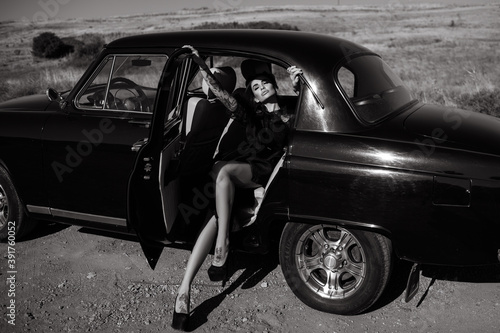 Gorgeous young Latino woman half lying on the passenger seat of her retro car enjoying the sunlight