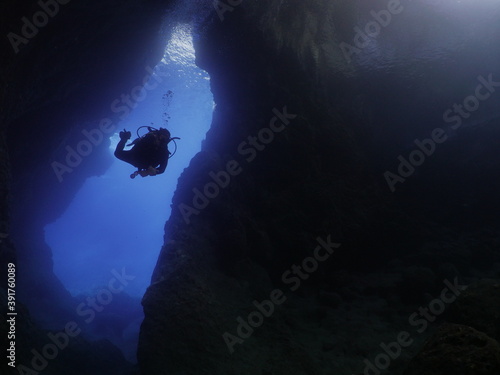 Photography scuba divers enjoying the topography and fauna underwater ocean scenery