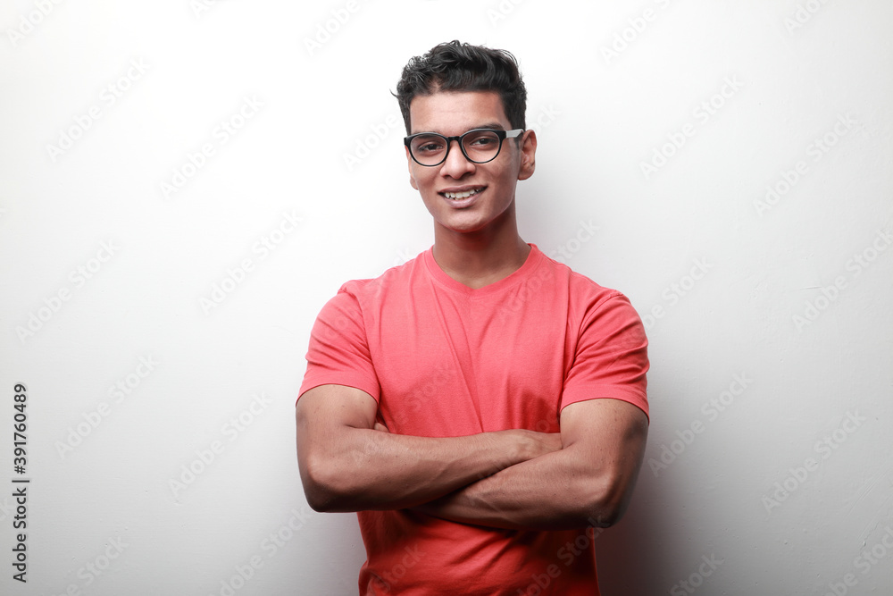 Confident smiling young man of Indian origin with folded hands Confident smiling young man of Indian origin with folded hands