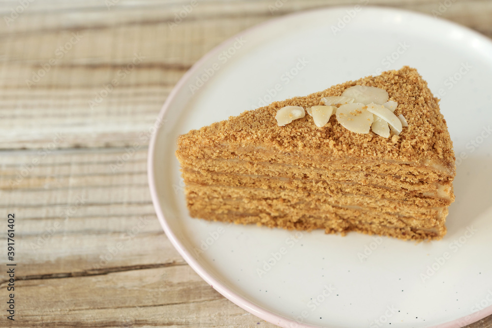 a piece of honey cake on a plate on a wooden table a piece of honey cake on a plate on a wooden table