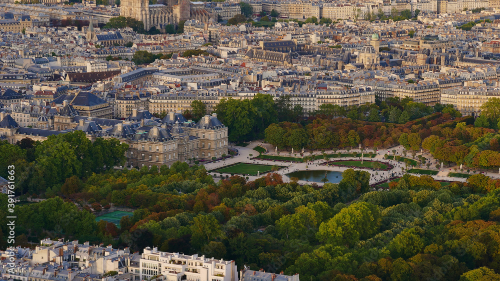 Beautiful aerial panorama view of famous park area Jardin du Luxembourg with historic Luxembourg Palace and discolored trees in early autumn in the dense city center of Paris, France.
