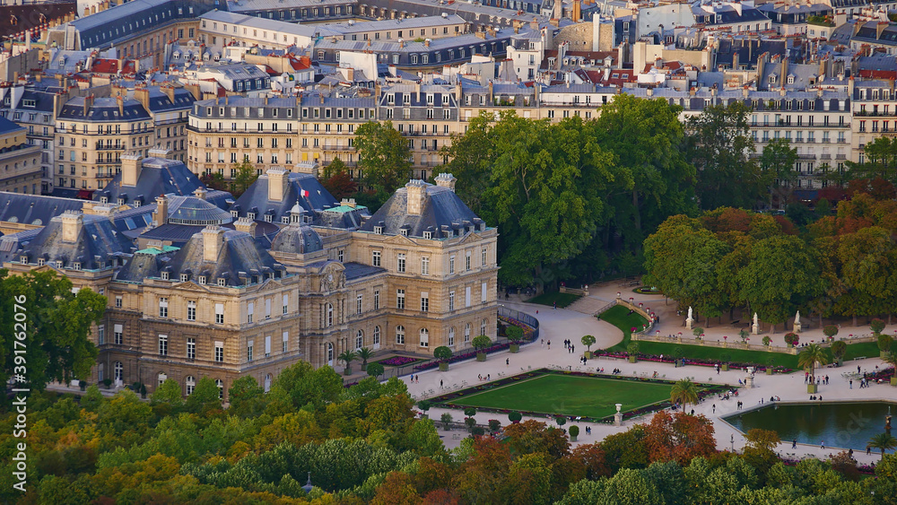 Closeup aerial view of famous Luxembourg Palace located in the garden area Jardin du Luxembourg in the historic center in Paris, France with beautiful discolored trees in autumn season.