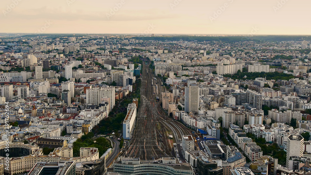 Aerial view of the eastern part of the historic city center of Paris, France with rail tracks leading to the train station Gare Montparnasse in the evening light.