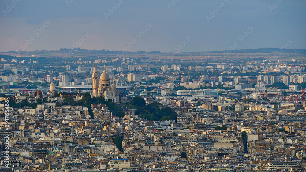 Closeup aerial panorama view of Montmartre hill in the north of the historic center of Paris, France with famous white colored cathedral Sacre-Coeur in the evening light.