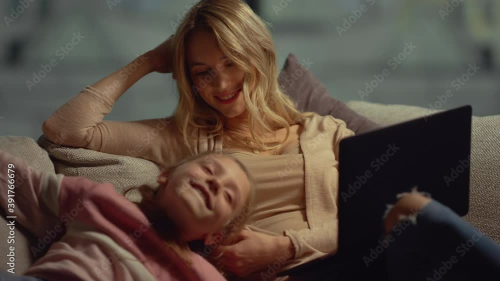 Mom with laptop chatting with daughter at home. Mother touching girl face couch Mom with laptop chatting with daughter at home. Mother touching girl face couch