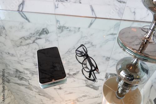 大理石風のインテリアに置かれたスマホと眼鏡smart phone and glasses on the marble desk