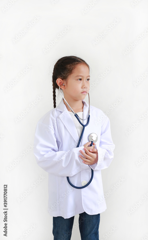 Portrait little asian kid girl with stethoscope while wearing doctor's uniform isolated over white background