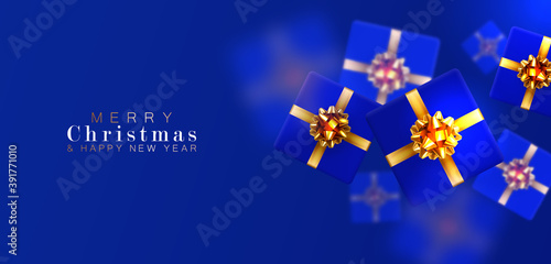 Gift box with motion blur effect. Merry Christmas and Happy New year. Realistic background with voluminous blue gifts tied with a gold ribbon with bows. The view from the top. Horizontal arrangement.