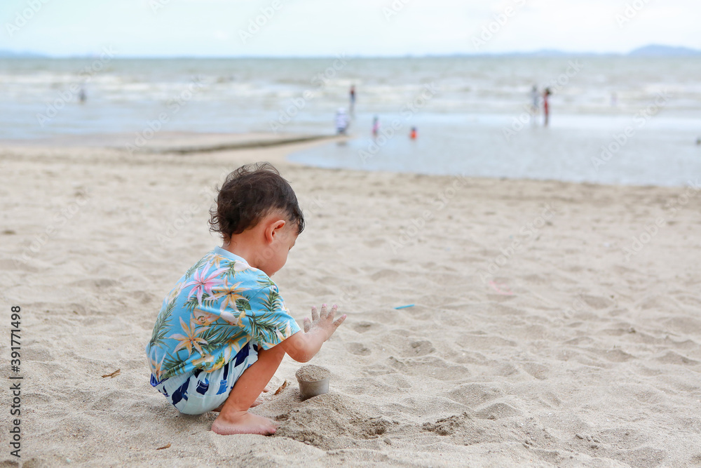 Portrait of little asian baby boy having fun with sand at the beach. Portrait of little asian baby boy having fun with sand at the beach.