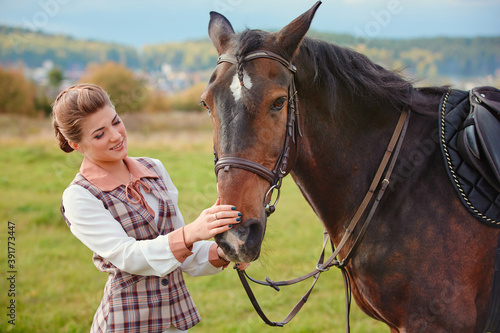 Beautiful elegant female rider next to the horse's muzzle. People and animals. Rider. © svetlanaz