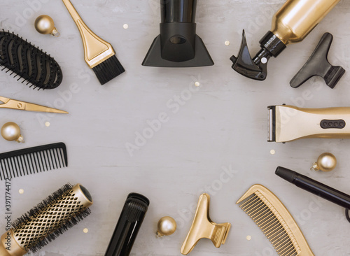 Template for new year and Christmas greetings with Hairdresser's tools. Gold and black hair salon accessories and balloons on a gray background with space for text.