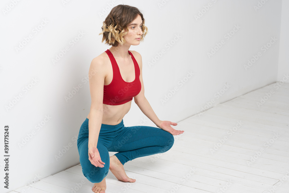 woman doing yoga full length indoors blue leggings red tank top woman doing yoga full length indoors blue leggings red tank top