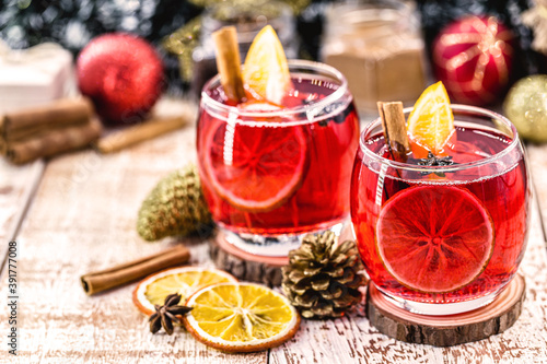 Christmas mulled red wine with spices and dried oranges on a rustic wooden table. Traditional hot drink for Christmas in the United States