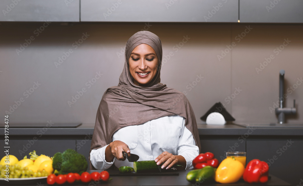 Muslim Wife Cooking In Modern Kitchen, Cutting Vegetables For Salad Muslim Wife Cooking In Modern Kitchen, Cutting Vegetables For Salad
