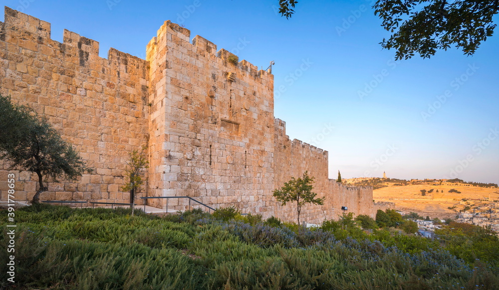 Southern wall of the Old City Jerusalem leading from the Zion's Gate down towards the Temple Mount, with Mount of Olives and its Russian Church of Ascension in the background