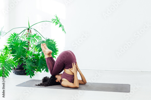 Beautiful woman yoga gymnastics flexible stretching asana fitness white room