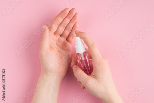 Top above overhead pov first person close up view photo of hands disinfection with sanitizer isolated on pastel pink color background with copyspace