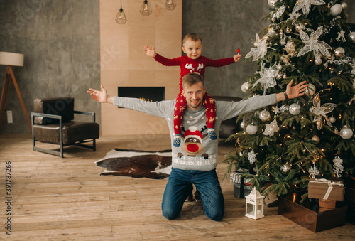 Happy father with his son have fun near Christmas tree.