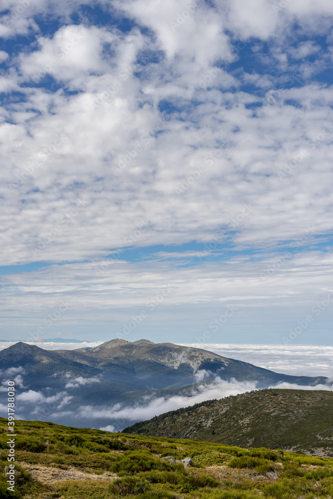Beautiful sea of clouds from a mountain on a sunny day. Low clouds in the Sierra de Guadarrama, Madrid.
