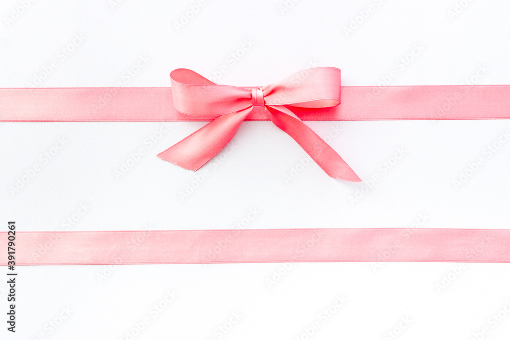 Pink ribbon with bow isolated on white for gift box. Top view, copy space