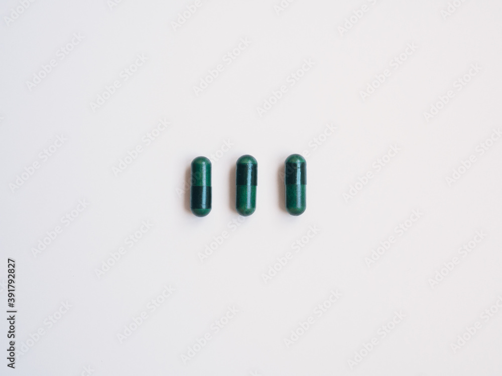 Three green pills, white background. Health concept Three green pills, white background. Health concept