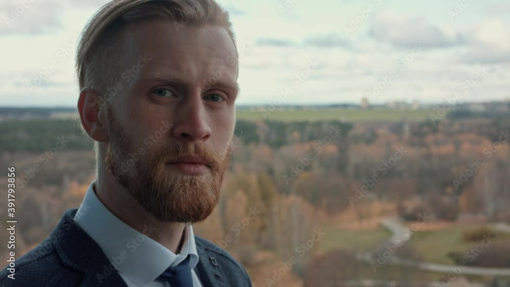 Closeup Portrait of confident successful attractive caucasian business person with beard and mustache, looking at camera serious. Businessman. Success concept. Formal black suit, tie Slow Motion Closeup Portrait of confident successful attractive caucasian business person with beard and mustache, looking at camera serious. Businessman. Success concept. Formal black suit, tie Slow Motion