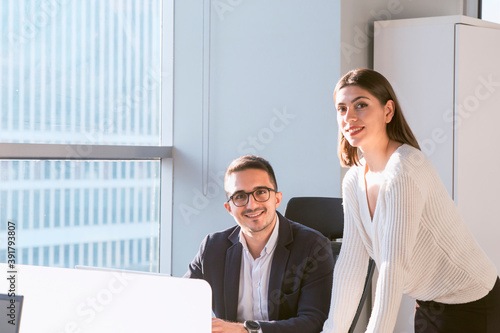 Woan manager and man data analyst looking to camera smiling with confident mood in a modern office