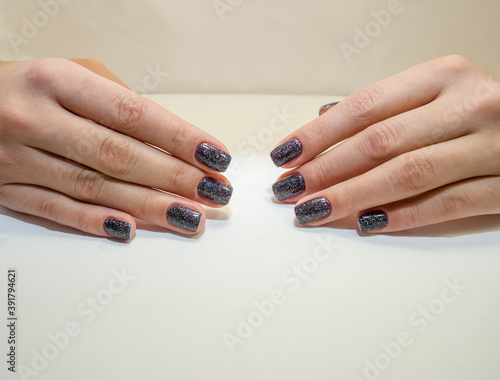 Stylish fashionable female manicure. Beautiful hands of a young woman on a light background. Close-up.