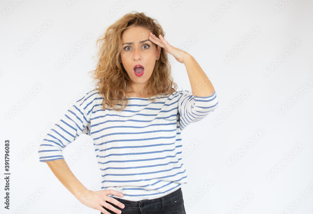 Beautiful woman with facial expression of surprise wearing casual striped t-shirt standing over white background. Beautiful woman with facial expression of surprise wearing casual striped t-shirt standing over white background.