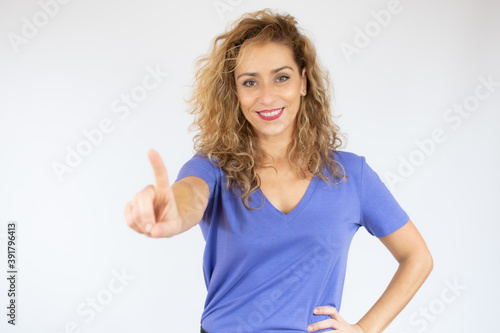 Wallpaper Mural Smiling woman in casual clothes pointing up and looking at the camera over white background Torontodigital.ca