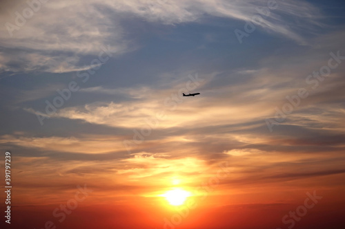 Beautiful sunset with clouds and a flying plane. Travel concept. Copy space for text.