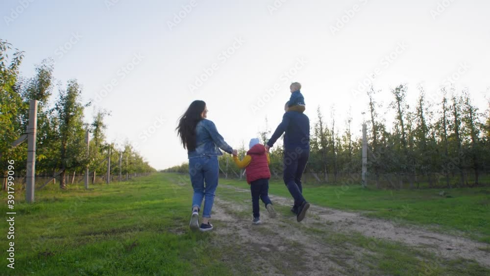 parents and children, caring loving mom and dad with baby around their neck hold their sons hands and have fun in countryside, lifestyle parents and children, caring loving mom and dad with baby around their neck hold their sons hands and have fun in countryside, lifestyle