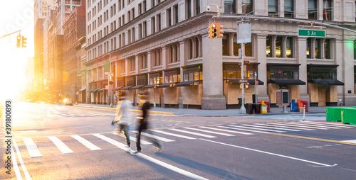 Photography People walking across the empty street intersection on Fifth Avenue past boarded
